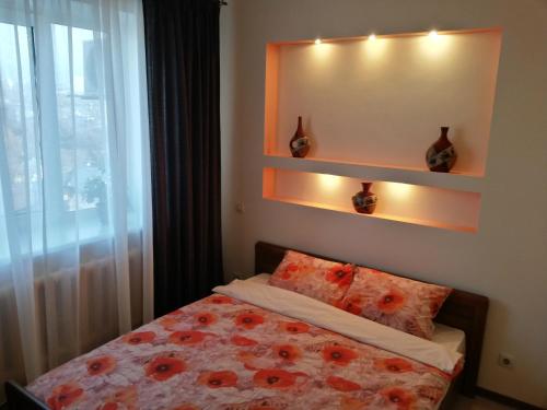 - une chambre avec un lit orné de fleurs rouges dans l'établissement "Атакент" Панорамный вид Квартира, à Almaty