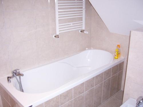 a white bath tub in a bathroom with a sink at Domwigierski pl -Jeziorki -GR- Comfort-Ferienhaus-Polen - własna linia brzegowa i sauna in Wysoki Most
