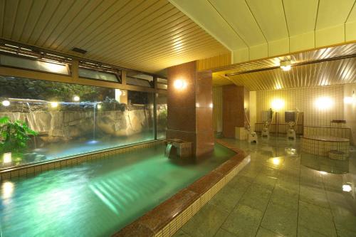 a large indoor swimming pool with a large window at Kasuitei Ooya in Fujikawaguchiko