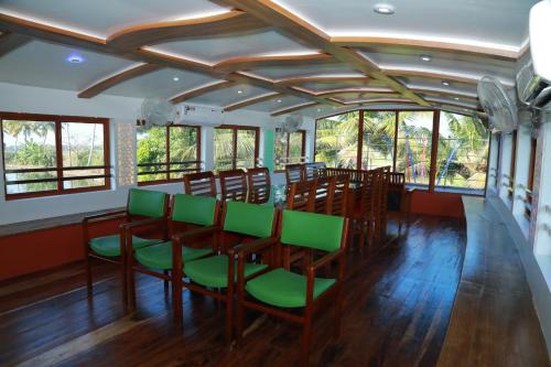 a room with a table and chairs and windows at Beach Paradise Day Cruise Houseboat in Alleppey