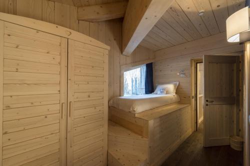 a bedroom in a log cabin with a bed at Chalet Morel 1586 Hotel & Spa in Limone Piemonte