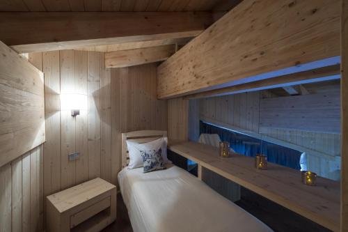a room with two beds in a wooden room at Chalet Morel 1586 Hotel & Spa in Limone Piemonte