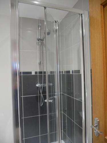 a shower with a glass door in a bathroom at 8 Swan House in Carnforth