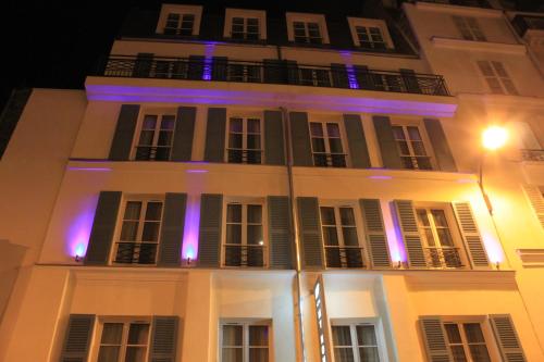 a building with two windows and a light on at My Home In Paris in Paris