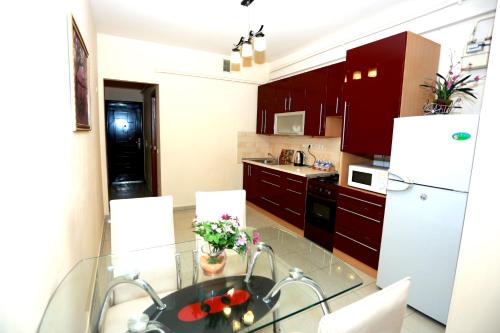 a kitchen with a glass table and a white refrigerator at Apartment.md in Chişinău
