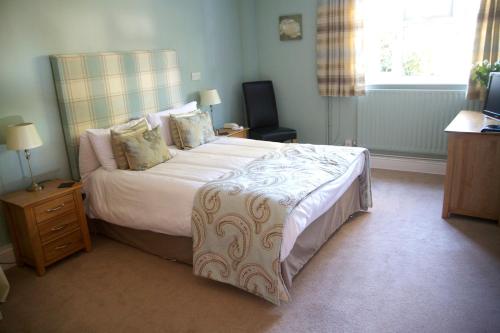 a bedroom with a large bed and a window at The Pytchley Inn in West Haddon