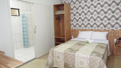 a bedroom with a bed and a shower at Coral Palace Hotel in Sangão