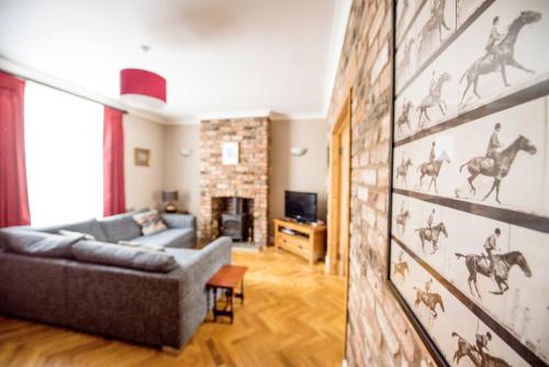 a living room with a couch and a wall with horse painting at Georgian Terrace, Chester in Chester