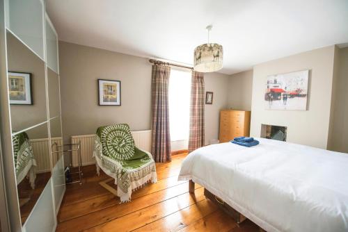 a bedroom with a bed and a chair and a window at Georgian Terrace, Chester in Chester