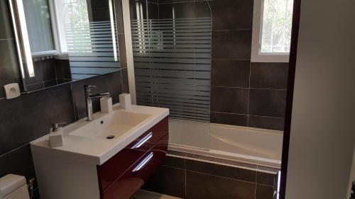 une salle de bain avec un lavabo et une baignoire dans l'établissement bord de mer, à La Ciotat