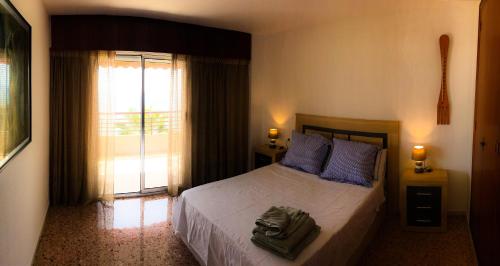 - une chambre avec un lit doté d'oreillers bleus et d'une fenêtre dans l'établissement 13 Rocafel 7 Playa Albufereta Alicante, à Alicante