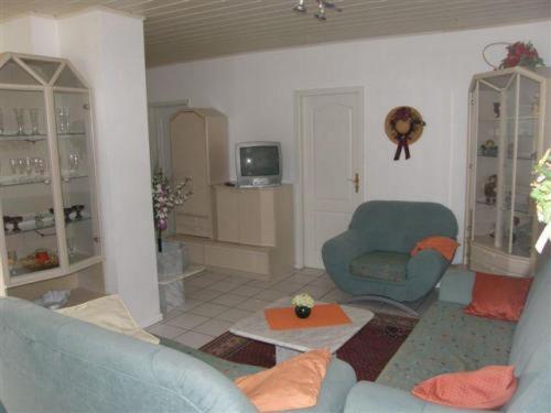a living room with two blue chairs and a tv at Appartements & Ferienwohnungen Wolf in Usingen