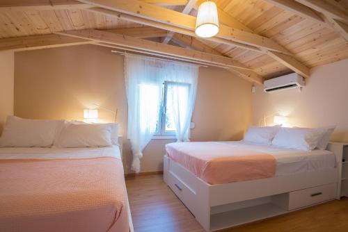 a bedroom with two beds and a window at Stavros Beach Garden Villa in Stavros