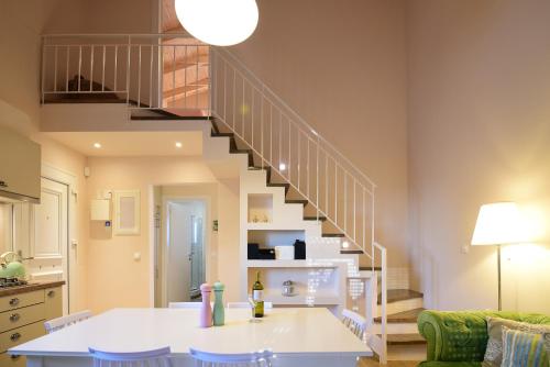 a staircase in a living room with a white table at Stavros Beach Garden Villa in Stavros