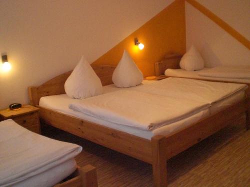 a bedroom with two beds with white sheets at Gasthof Fröhlich in Langenbruck