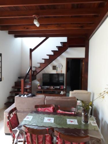 uma sala de estar com uma mesa e uma escada em Casa Gomes Itagua em Ubatuba
