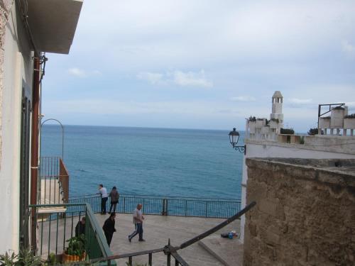 a group of people walking on a balcony looking at the ocean at B&B Casa Dorsi in Polignano a Mare