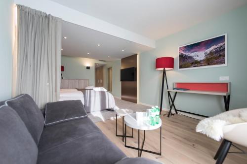a living room with a couch and a bed at Hotel Rosatsch in Pontresina