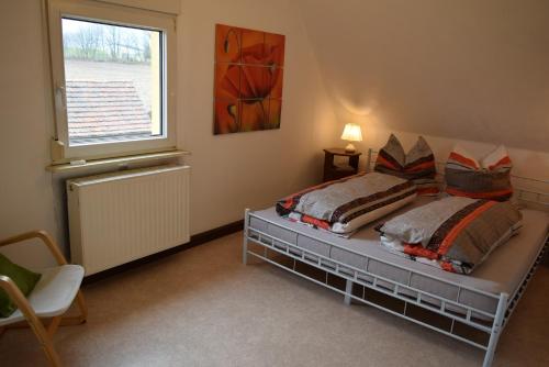 ein Schlafzimmer mit einem Bett mit zwei Kissen und einem Fenster in der Unterkunft Ferienhaus Dresden Bühlau in Dresden