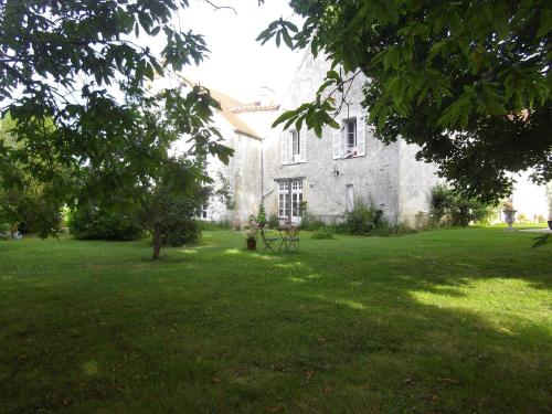 an old stone house with a grass yard in front of it at La Fruitiere in Saints