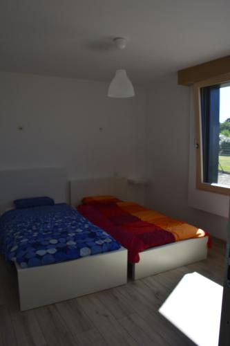 ネヴェにあるMaison bord de mer avec jacuzziのベッドルーム1室(ベッド2台、窓付)