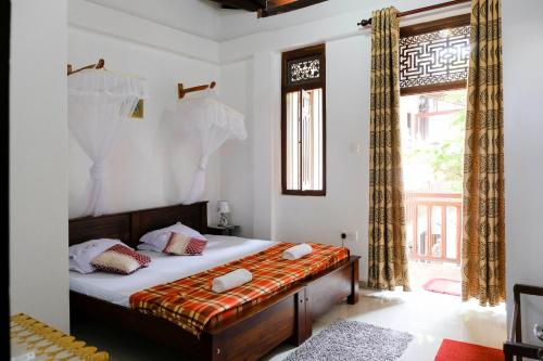 a bedroom with a bed and a window at Southern Comforts - Galle Fort in Galle