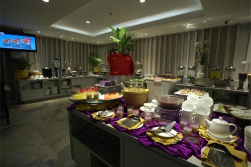 a buffet of food on a table in a kitchen at Tjokro Hotel Pekanbaru in Pekanbaru