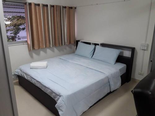 a bedroom with a bed with white sheets and a window at New Room in Nonthaburi