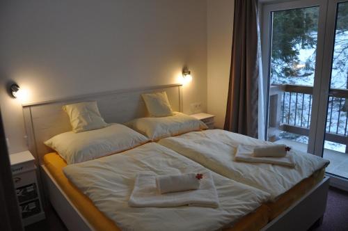 a bedroom with a large bed with towels on it at Apartmán 14 Lúčky Demänovská dolina in Belá