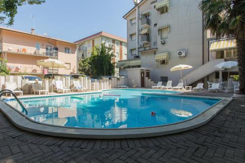 a large swimming pool in front of a building at Hotel New York in Cervia