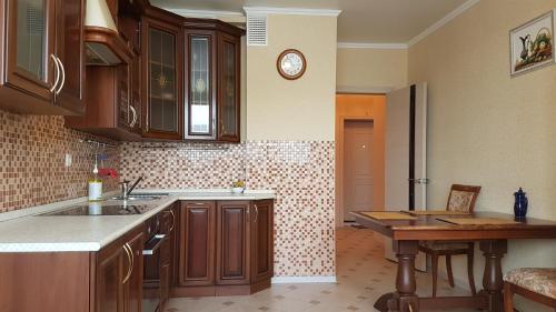 a kitchen with wooden cabinets and a table in it at Apartments Avrora, Gagarina 75 in Oryol