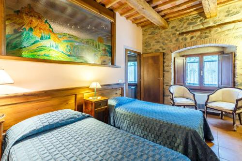 a bedroom with two beds and a painting on the wall at Villaggio Albergo San Lorenzo e Santa Caterina in Pescia