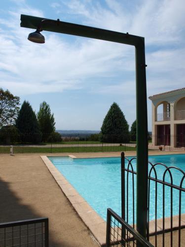 - une piscine lumineuse à côté d'un bâtiment dans l'établissement La Ginelle - Appartement Savane, à Airoux