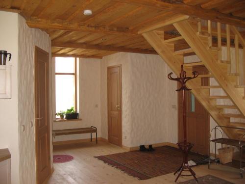 a living room with wooden ceilings and a staircase at Kõrgemäe puhketalu in Eoste