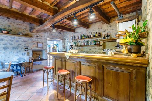 un bar con armarios de madera y taburetes en un restaurante en Villaggio Albergo San Lorenzo e Santa Caterina, en Pescia