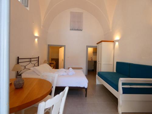 a bedroom with a bed and a table and a couch at Pantelia Pyrgos in Pyrgos