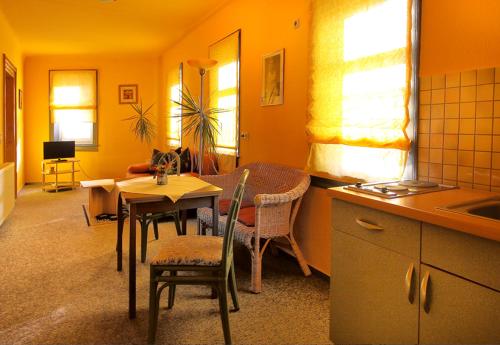 a kitchen with a table and chairs and a dining room at Gaststätte und Pension Felsenthal in Tabarz