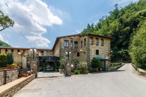 a large stone building on a road at Villaggio Albergo San Lorenzo e Santa Caterina in Pescia