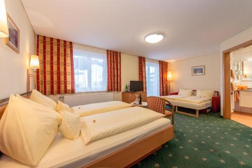 a hotel room with two beds and a living room at Pension Elisabeth in Russbach am Pass Gschütt