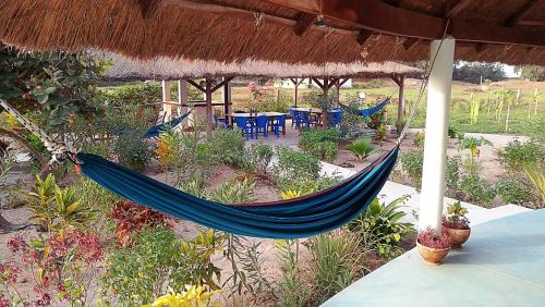 a hammock in a resort with a table and chairs at Le Papayer Écolodge in Boukot Ouolof