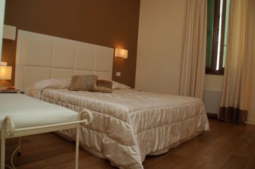 a bedroom with a bed and a bench in it at Oro Rosso Hotel Ristorante in Montefalco