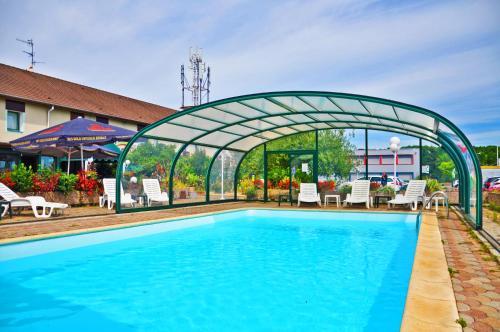 a swimming pool with a green arch over it at Contact Hôtel Arc-En-Ciel - Réouverture - Rénové in Mulhouse