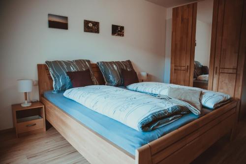 Una cama con sábanas azules y almohadas. en Ferienwohnung Thannen, en Lingenau