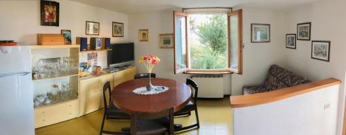 a kitchen and dining room with a table and a refrigerator at Appartamento Colombere Priori Elisabetta in Malcesine