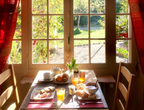 a table with breakfast food on it in front of a window at La Villa du Parc in Prades
