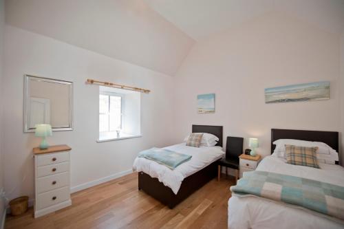 twee bedden in een slaapkamer met witte muren en houten vloeren bij Lady Macbeths Rest in Banchory
