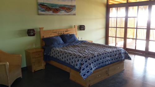 a bedroom with a bed with a blue and white comforter at Villa al Fe in Los Órganos