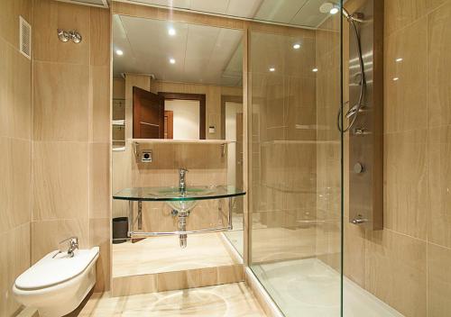 y baño con ducha acristalada y lavamanos. en WaterFront Apartment, en Estepona