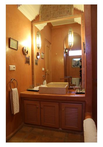 a bathroom with a sink and a large mirror at La Maison de Tanger in Tangier
