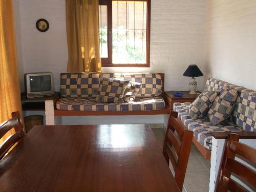 a living room with couches and a table and a tv at Adi y Dina Cabañas in La Paloma